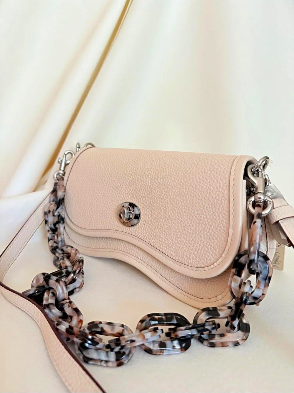 Beige Pebbled Crescent Crossbody Bag Silver Turn Lock Tortoise Chain Strap